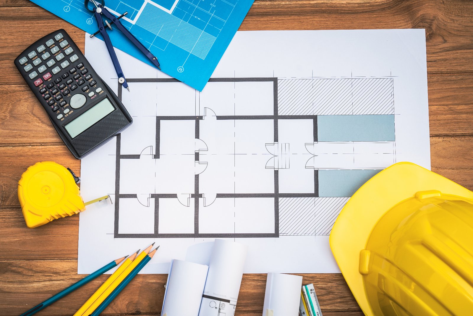 Architectural planning with blueprints, hard hats, and tools on a modern construction desk in Shrewsbury